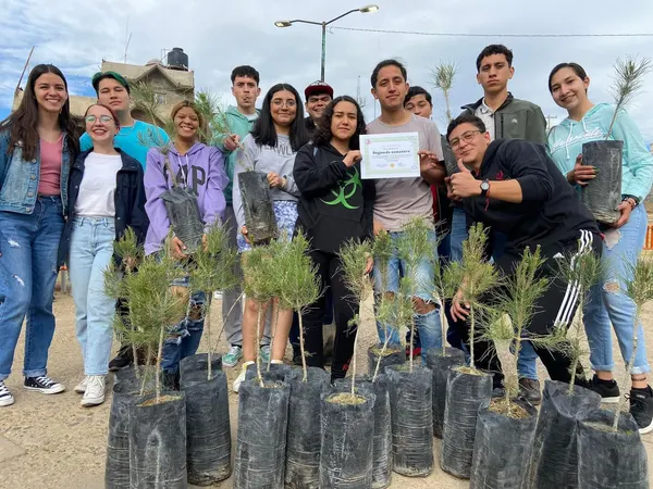Estudiantes del IISCH con los arbolitos de una jornada de reforestación